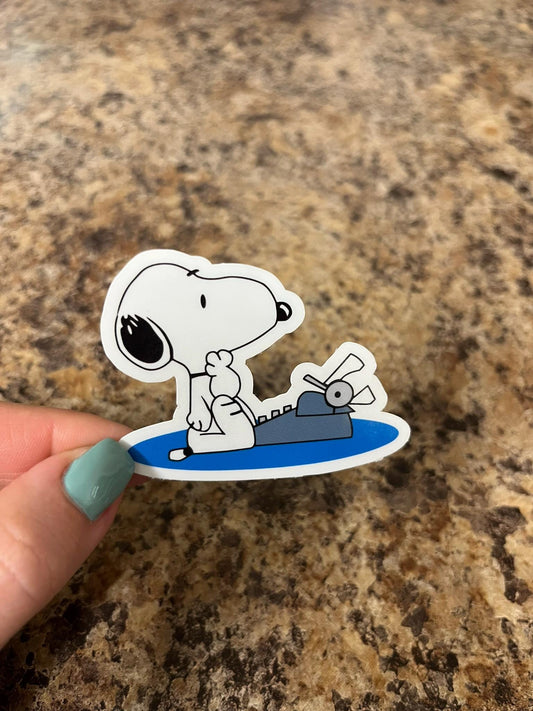 Snoopy Writing Typewriter Sticker – Funny Cartoon Dog Vinyl Sticker for Writers, Book Lovers, and Peanuts Fans – 2.5"x2" Waterproof